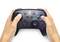 Eine Person hält einen Nintendo Switch Pro Controller mit hell leuchtenden Tasten und geprägten Designs.