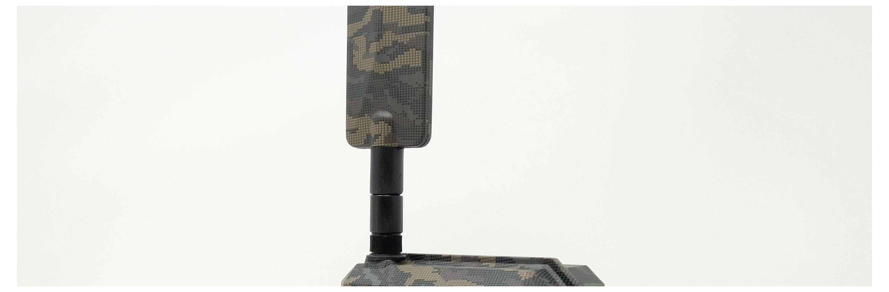 Ein Gerät mit Tarnmuster, bestehend aus einem rechteckigen Teil auf einem schwarzen Standfuß, vor weißem Hintergrund.