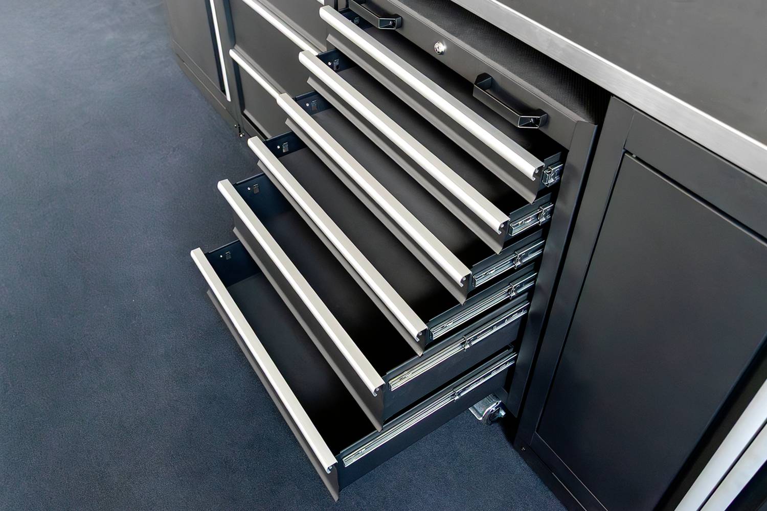 Mehrere geöffnete Schubladen in einem schwarzen Küchenschrank offenbaren Stauraum, um Ordnung und Übersichtlichkeit zu gewährleisten.