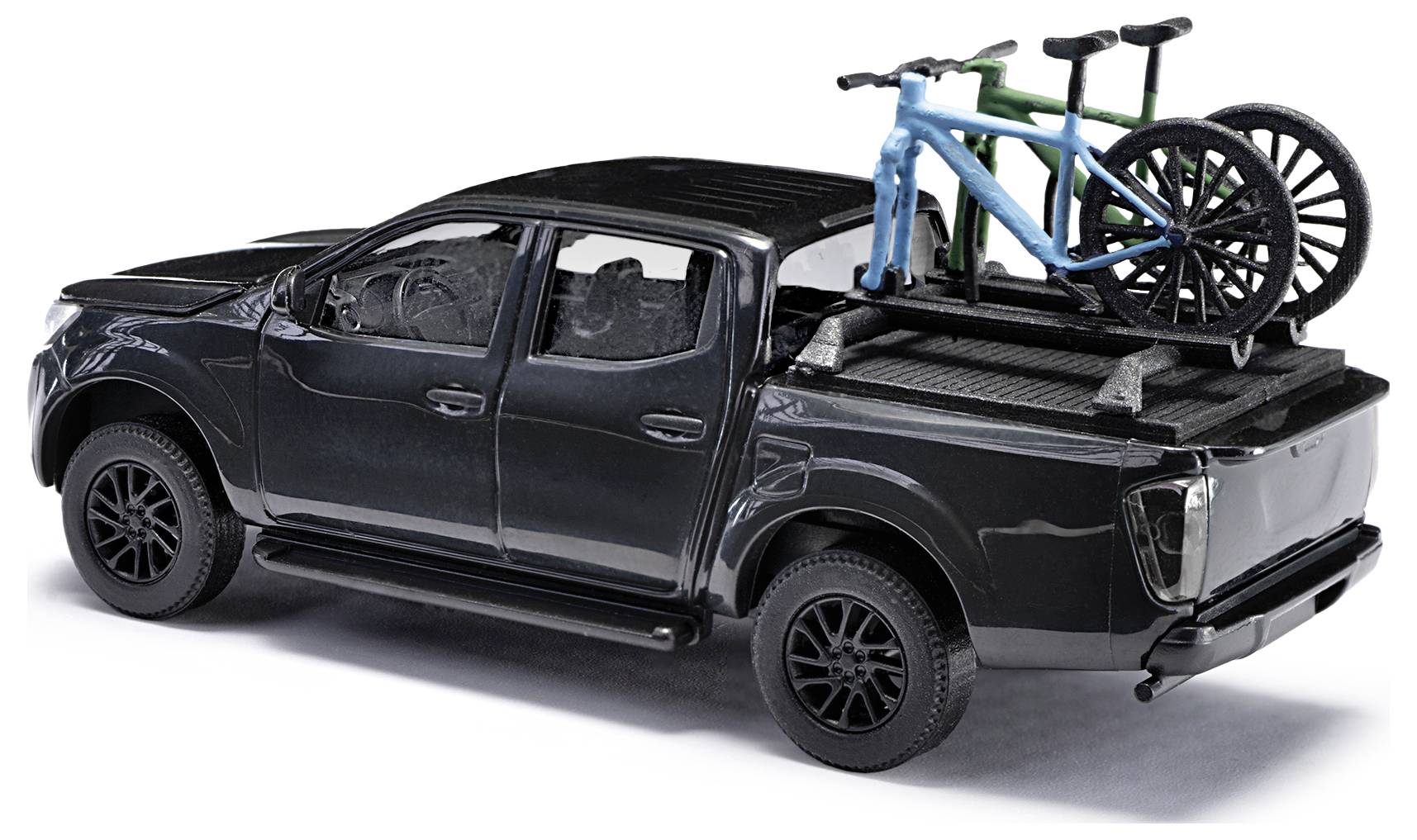 Schwarzer Pickup-Truck mit zwei Fahrrädern auf dem Heck, dargestellt in einem Modell im Maßstab.