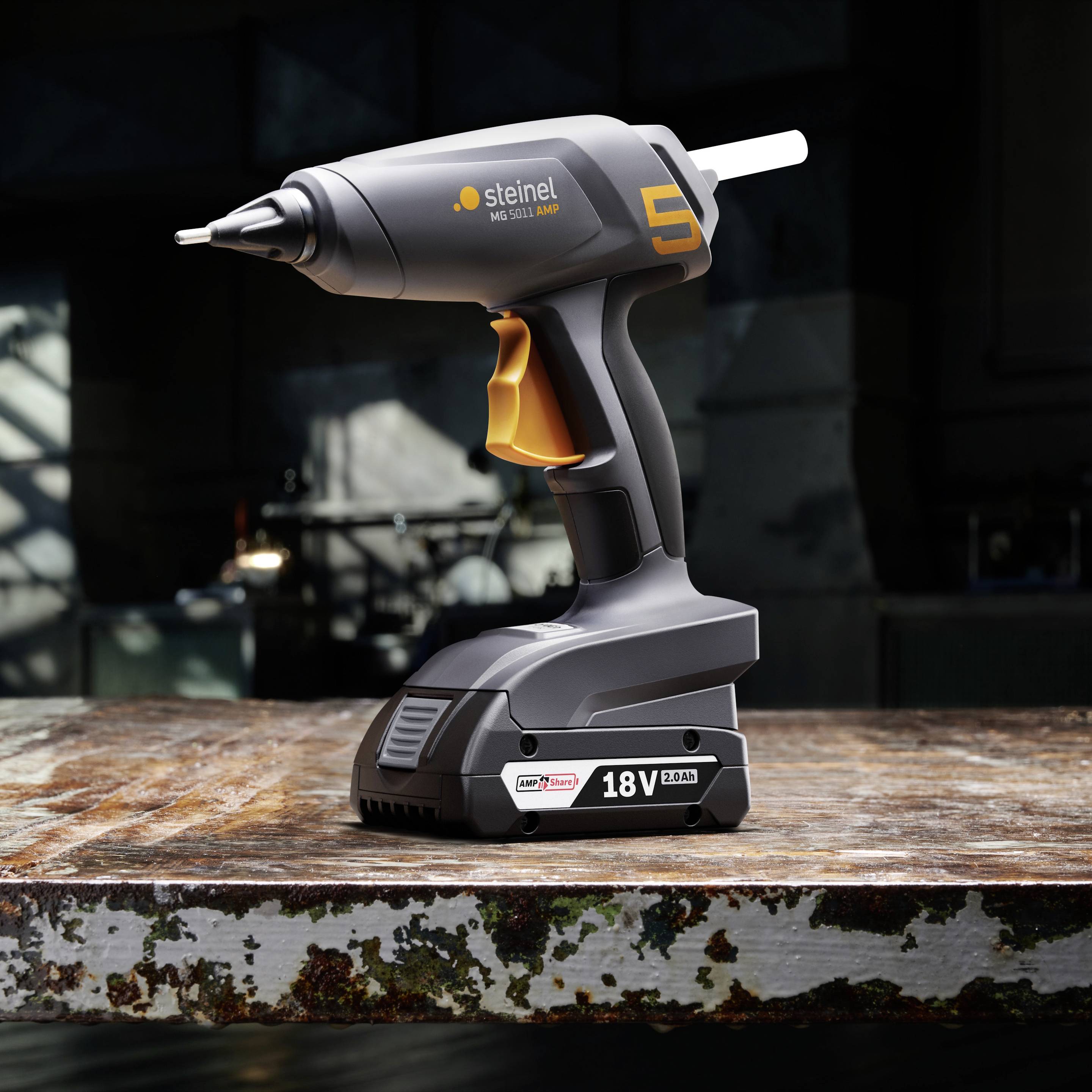 Akku-Heißklebepistole auf einem Tisch, Modell 'Steinel NEO3'. Robust, kabellos, geeignet für vielfältige Klebeanwendungen.