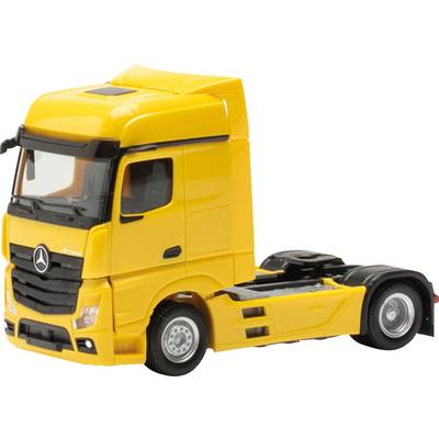 Gelbes Modell eines Lastwagens ohne Anhänger, auf einem weißen Hintergrund. Der Fokus liegt auf der Fahrerkabine.