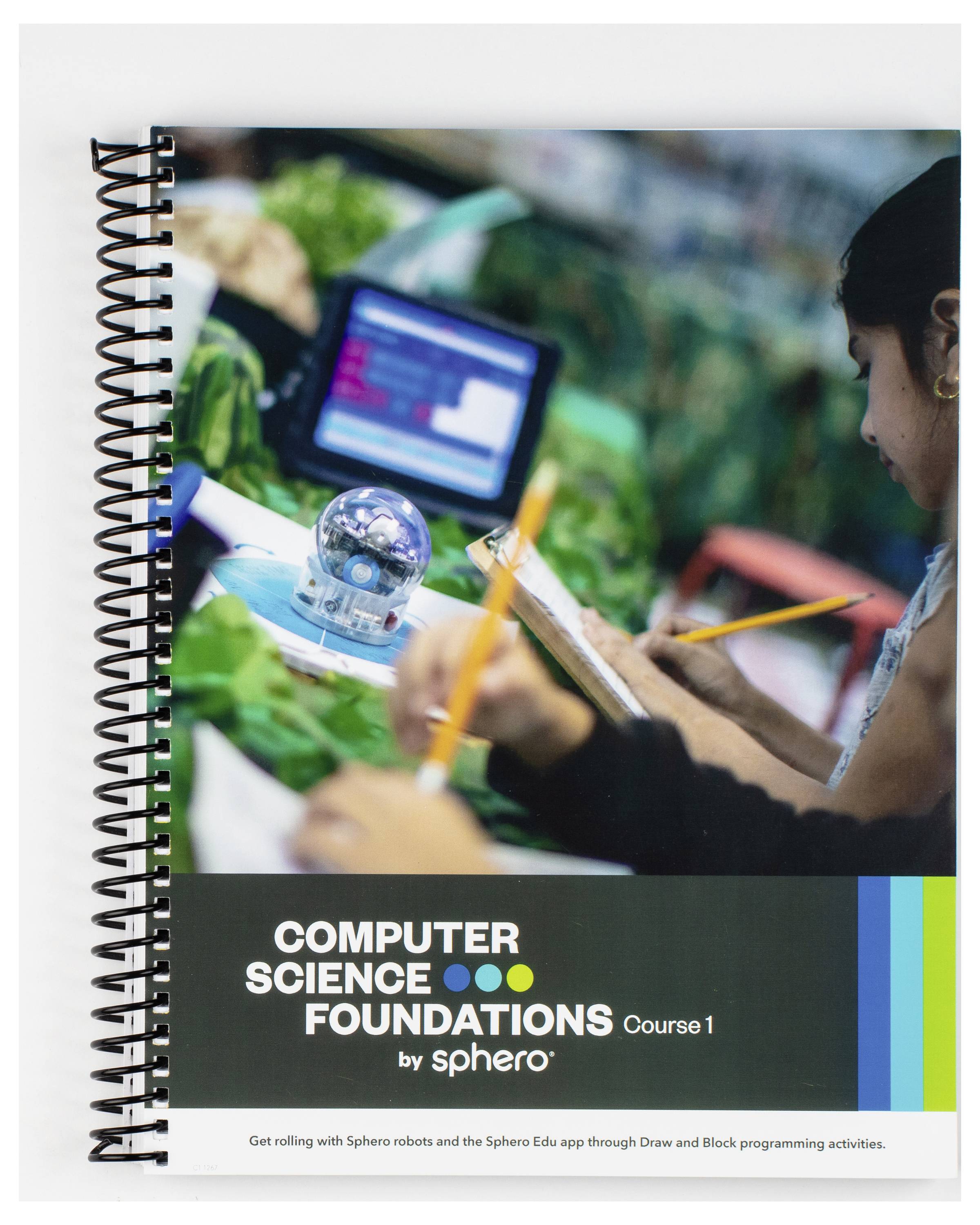 Ein aufgeklapptes Schulbuch mit dem Titel 'Computer Science Foundations Course 1 by Sphero' zeigt Lernmaterial und digitale Geräte.