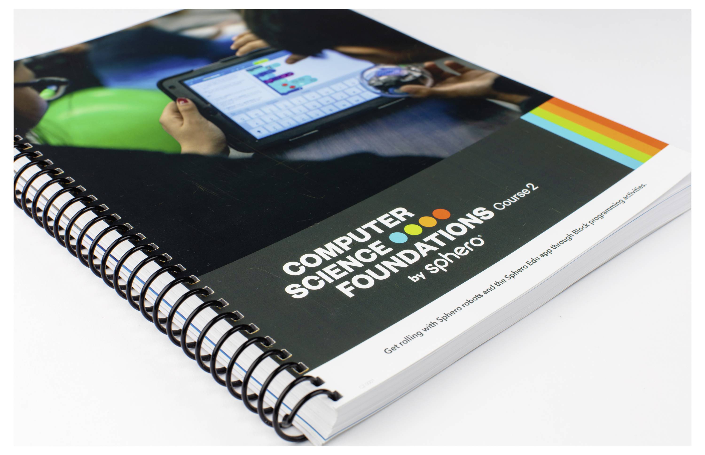 Foto eines Spiralbuchs mit dem Titel 'Computer Science Foundations Course 2 by Sphero'. Personen interagieren mit einem Tablet.