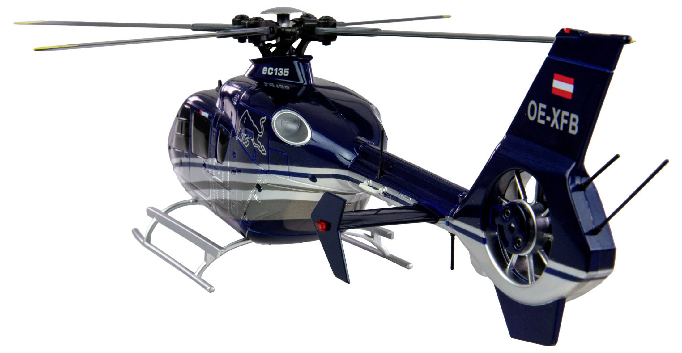 Ein dunkelblauer Modellhubschrauber präsentiert sich von der Seite. Auf der Vorderseite steht 'EC135', am Heck sind Buchstaben und eine Flagge zu sehen.