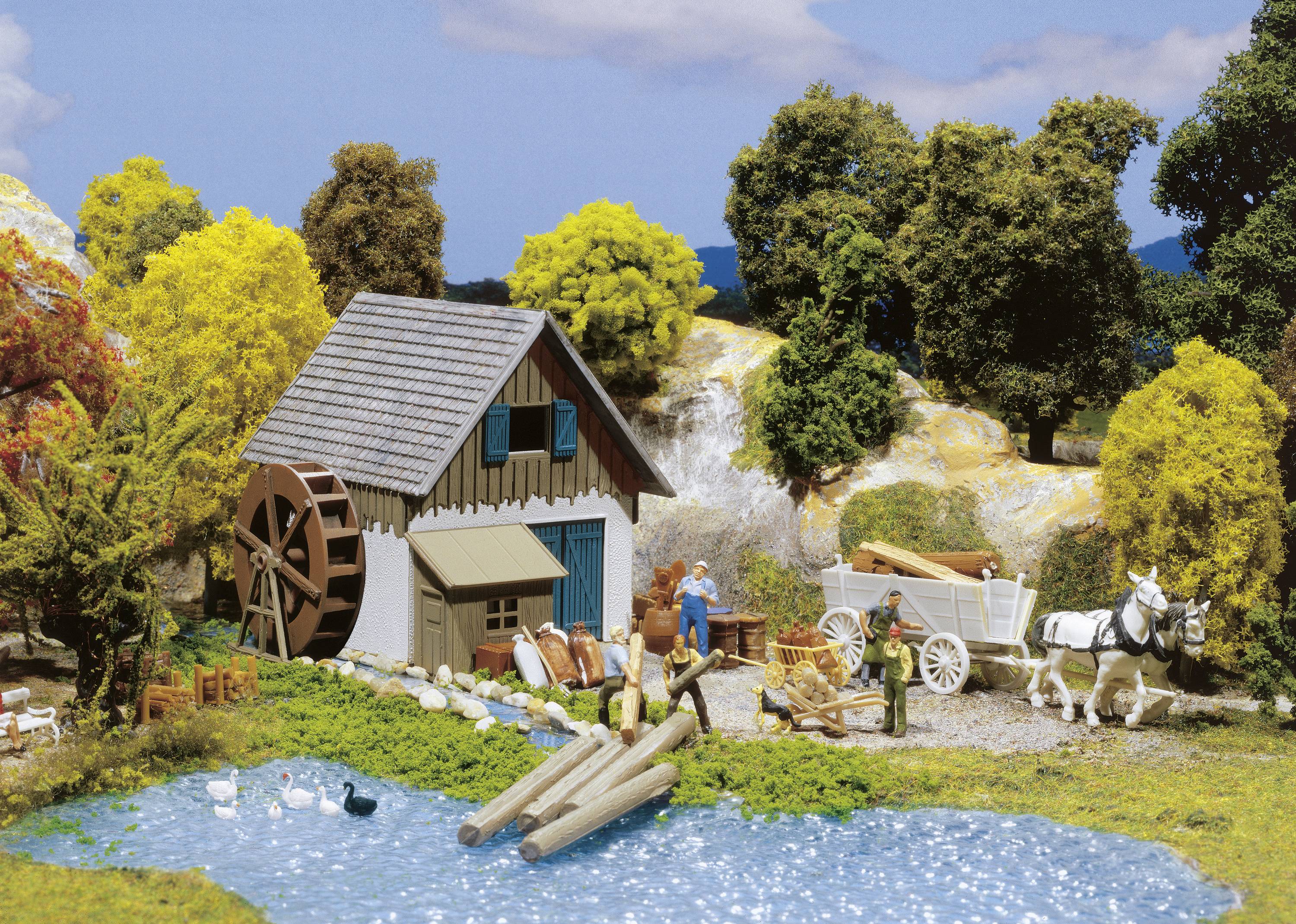 Miniaturszene: Alte Wassermühle an einem Teich, umgeben von Bäumen. Menschen laden Holz auf eine Pferdekutsche. Enten im Wasser.
