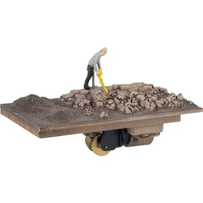 Ein Miniaturmodell zeigt eine Person, die mit einem Metalldetektor auf felsigem Terrain nach Objekten sucht.