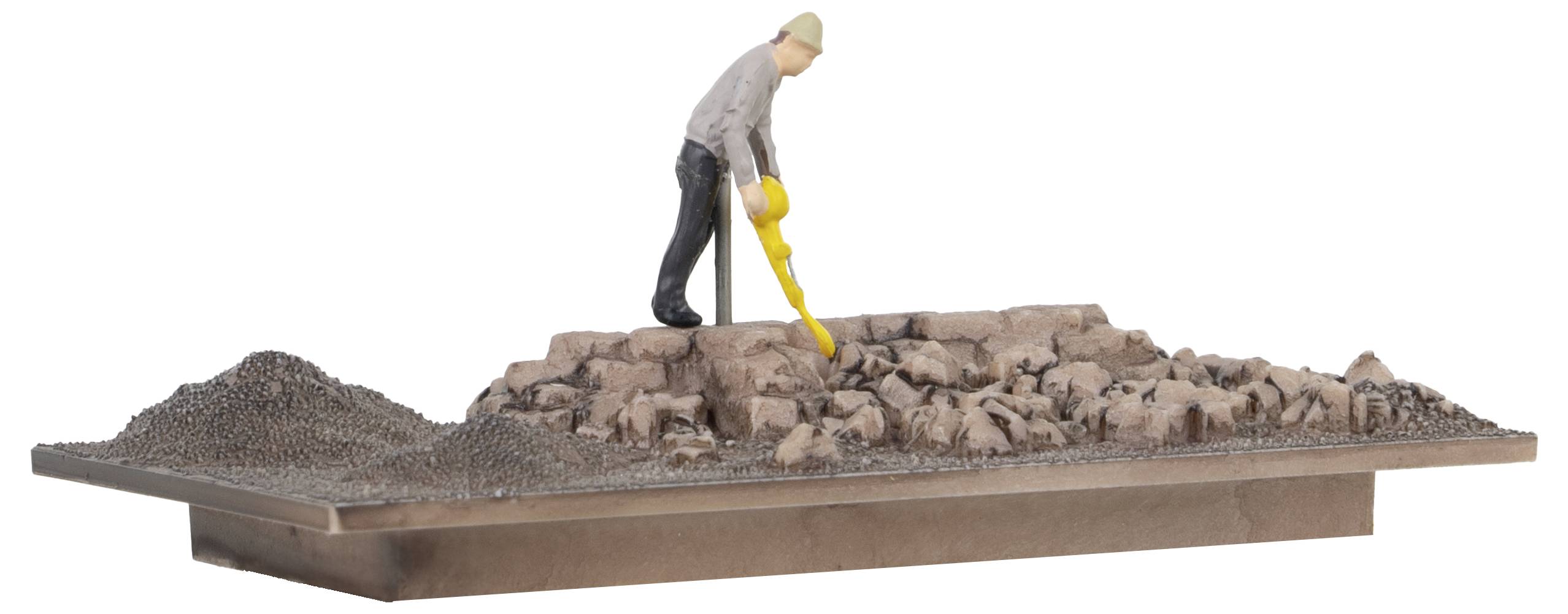 Eine Miniaturfigur steht auf einem Felsen, hält ein gelbes Gerät und scannt den Boden.