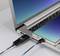 Ein Smartphone ist über ein USB-Kabel mit einem Laptop verbunden, was einen Datentransfer oder Ladevorgang andeutet. Beide Geräte sind eingeschaltet.