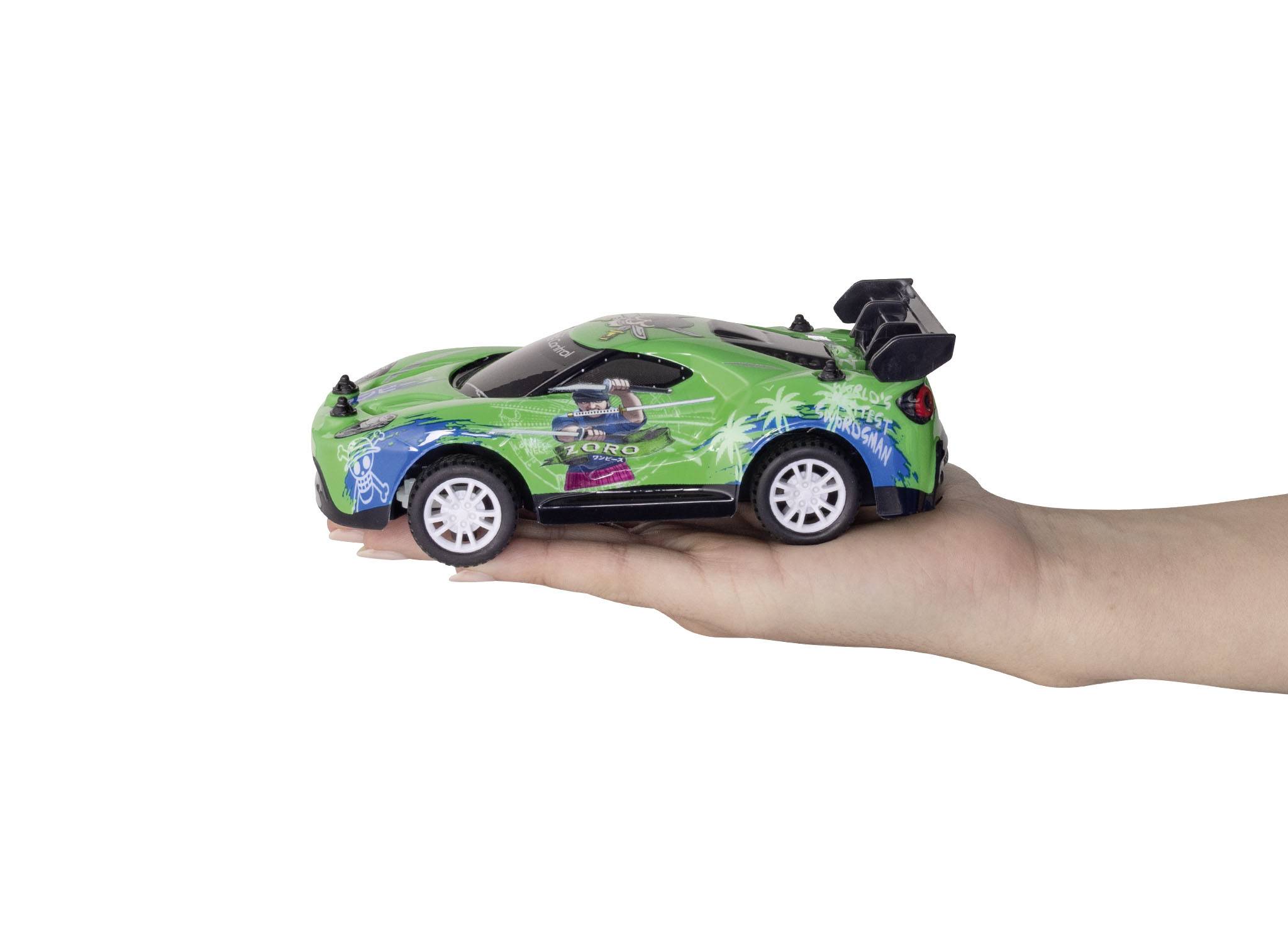 Eine Hand hält ein kleines, grünes Spielzeugauto mit bunten Grafiken und Spoiler, seitlich fotografiert.