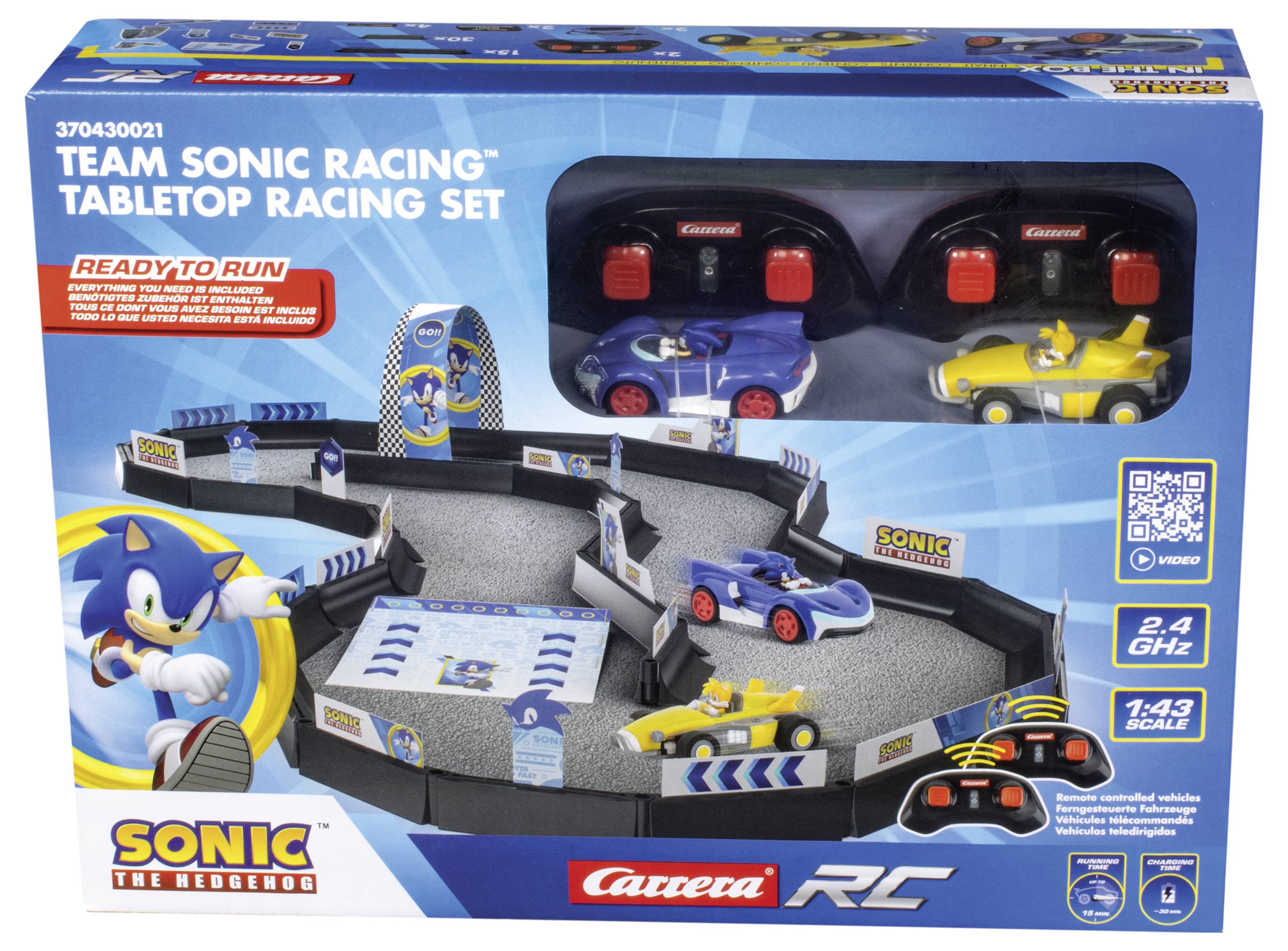 Eine Spielzeug-Rennstrecke mit zwei Autos und Fernbedienungen im 'Team Sonic Racing' Design. Verpackung zeigt Sonic und Rennbahn.