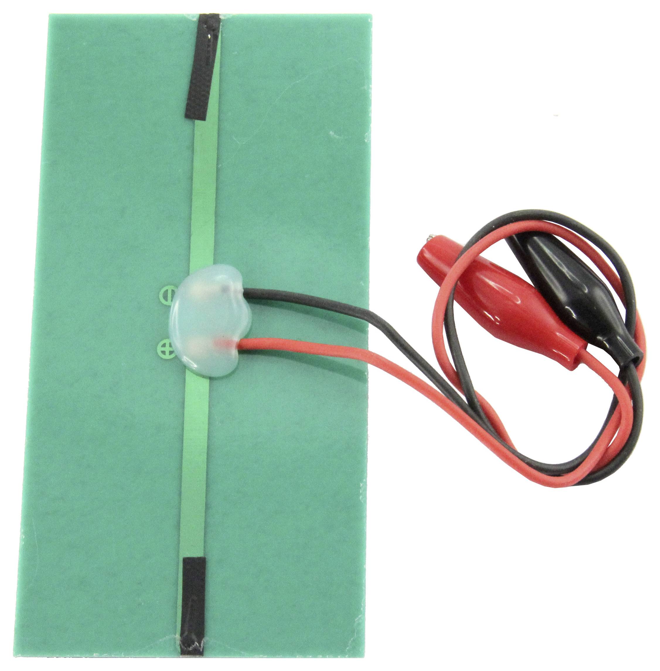 Grünes Thermoelement mit zwei angebrachten Krokodilklemmen zum Testen von elektrischen Verbindungen, auf weißem Hintergrund.