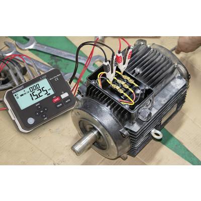 Elektromotor mit Kabeln, die an einen Multifunktions-Kalibrator angeschlossen sind, der '1525' anzeigt. Schraubschlüssel im Hintergrund deuten auf Wartungsarbeiten hin.