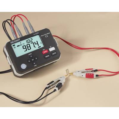 Ein digitales Voltmeter mit roten und schwarzen Messleitungen zeigt '98,74' an. Die Messleitungen sind mit einem kleinen Widerstand verbunden.