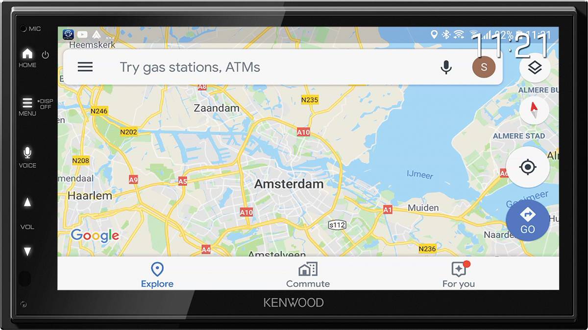 Navigationsgerät mit Google Maps zeigt eine Karte mit Amsterdam im Zentrum. Oben suchbar: 'Try gas stations, ATMs'. Uhrzeit: 11:21.