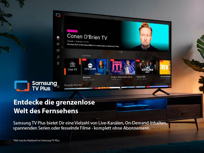 Samsung TV Plus auf einem Tisch. Der Bildschirm zeigt 'Conan O'Brien TV' und andere Kanäle. Text unterstreicht die Vielfalt der Fernsehinhalte.
