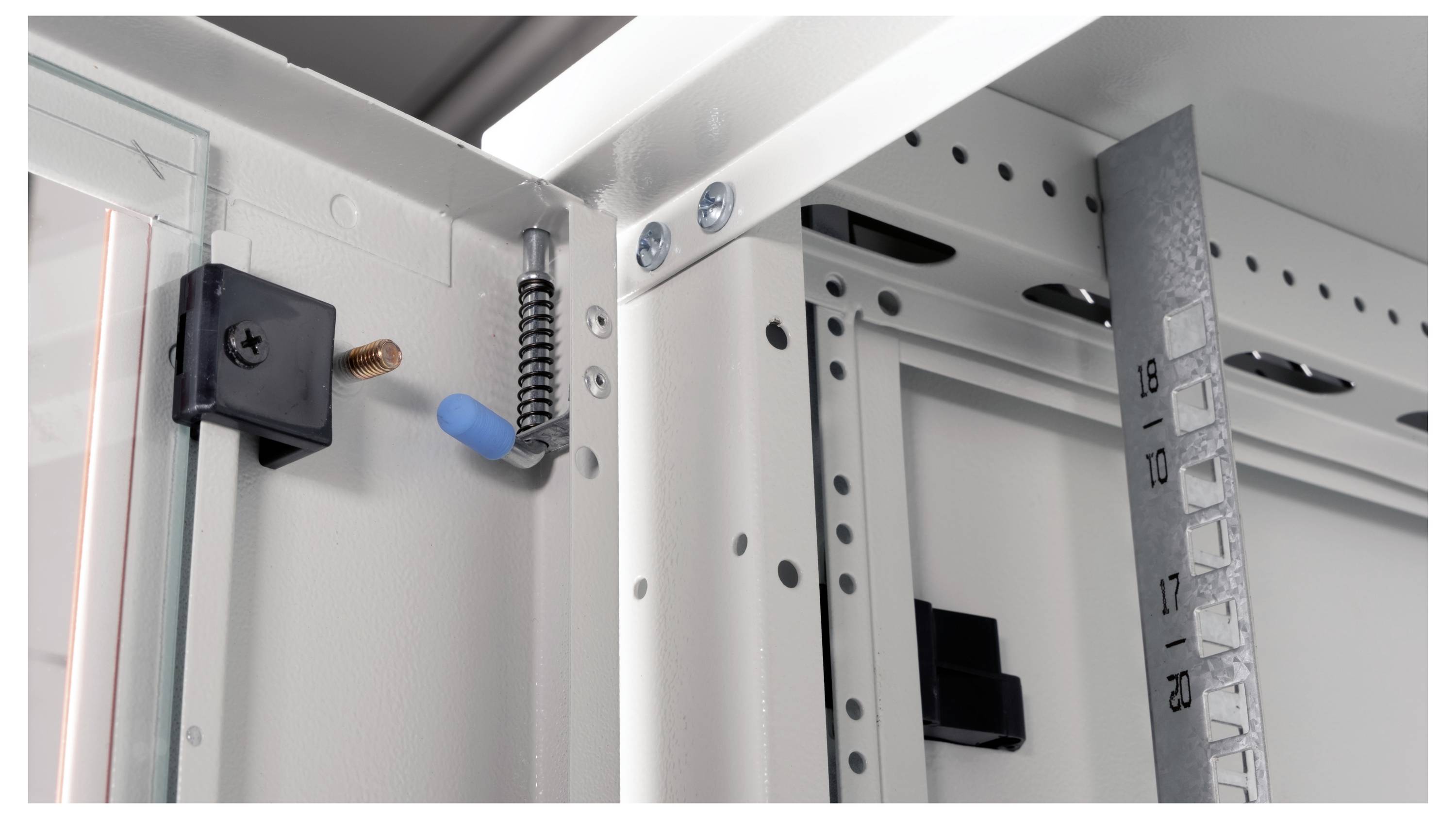 Nahaufnahme eines geöffneten elektrischen Schaltschranks, die Innendetails wie einen Werkzeughaken, Schrauben und ein Maßband zeigt.