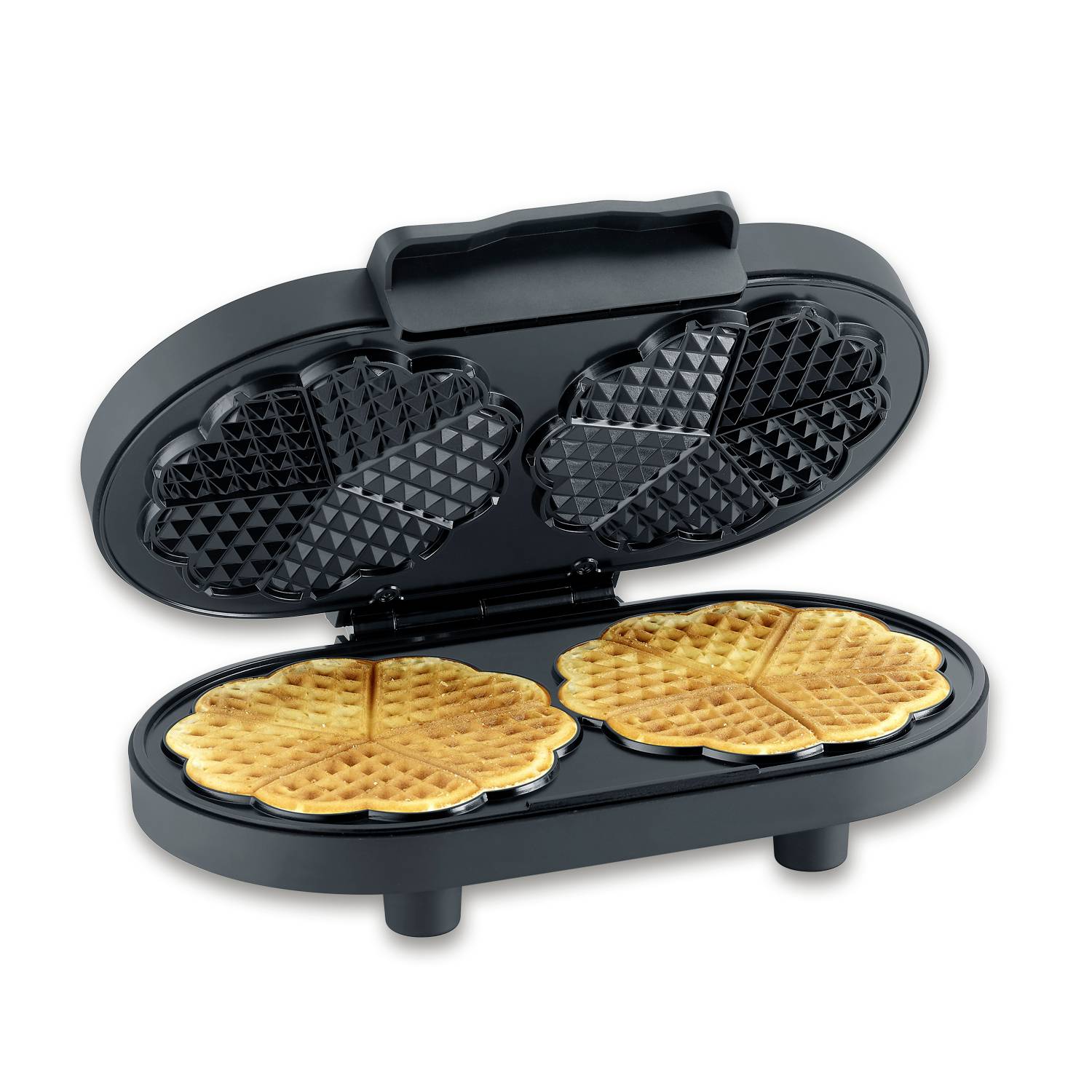 Waffeleisen geöffnet mit zwei frisch gebackenen goldbraunen Herzwaffeln.