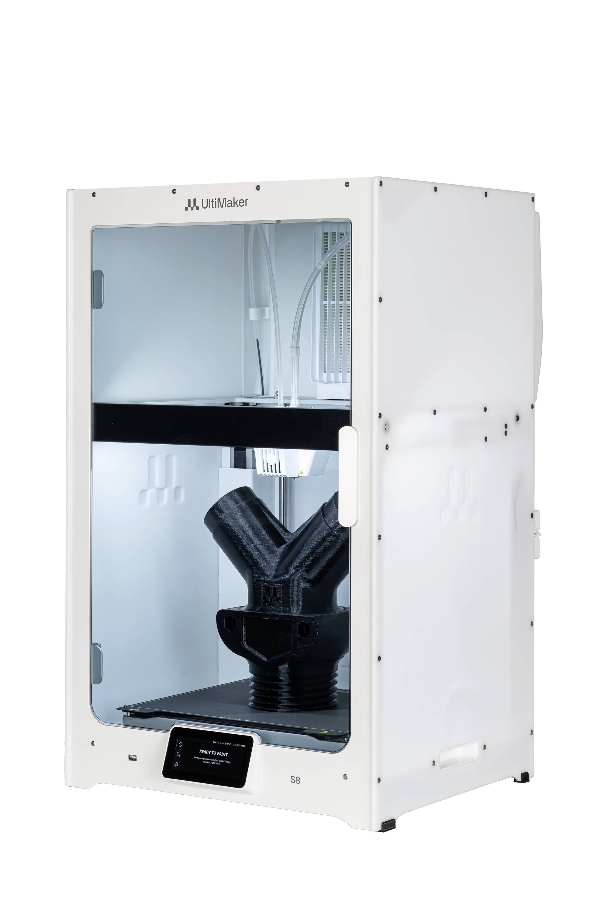 Ein 3D-Drucker druckt ein großes Objekt in schwarzem Material. Der Druckvorgang ist in einem beleuchteten, geschlossenen Gehäuse sichtbar.