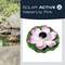 'SOLAR ACTIVE WaterLily Pink' zeigt eine Solarlampe in Form einer rosa Seerose; sie schwimmt in einem Teich mit anderen Blumen.