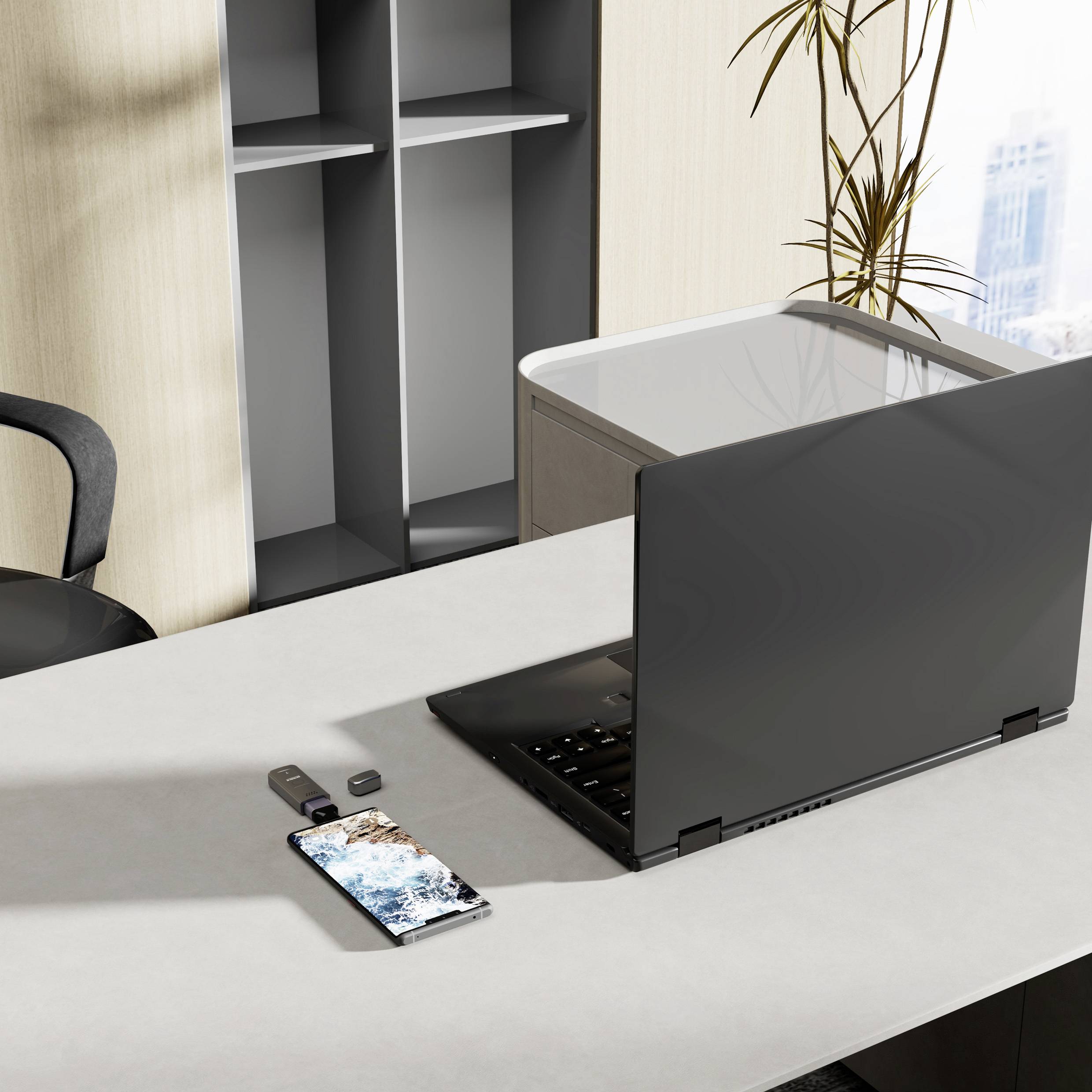 Ein moderner Büroschreibtisch mit einem geschlossenen Laptop, einem Smartphone, das eine Karte zeigt, und einem USB-Stick, was eine digitale Arbeitsplatzeinrichtung andeutet.