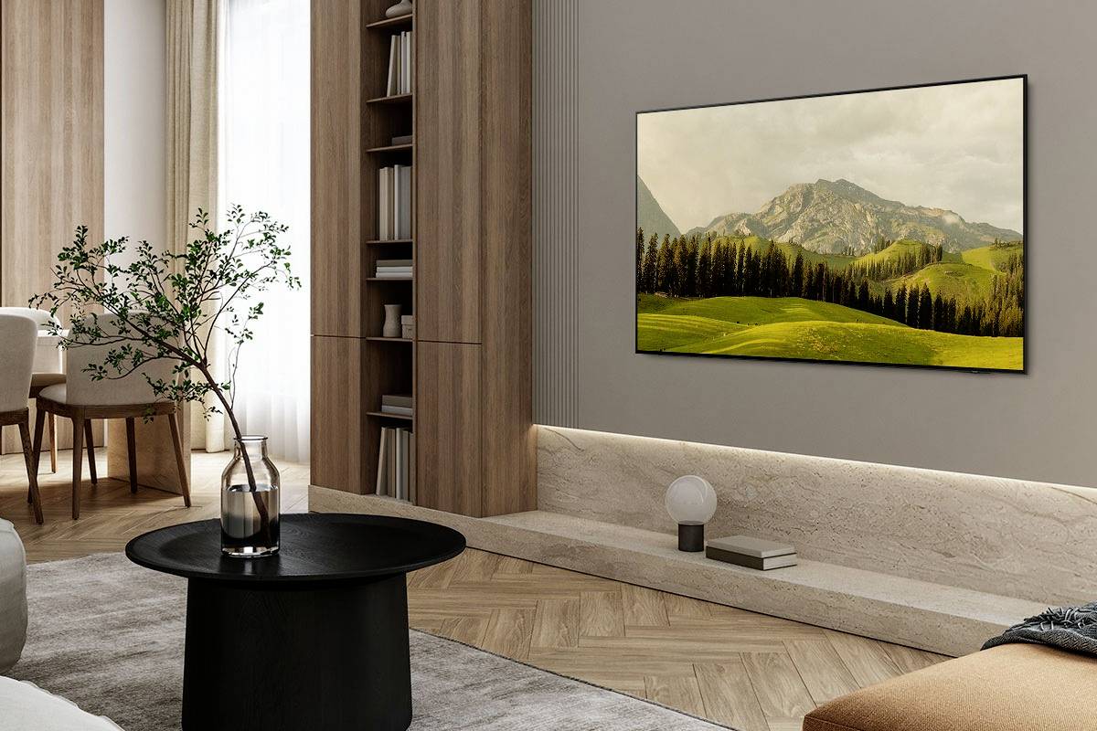 Ein gemütliches Wohnzimmer mit moderner Einrichtung, einem runden Tisch, Pflanzen und einem großen Landschaftsbild an der Wand.