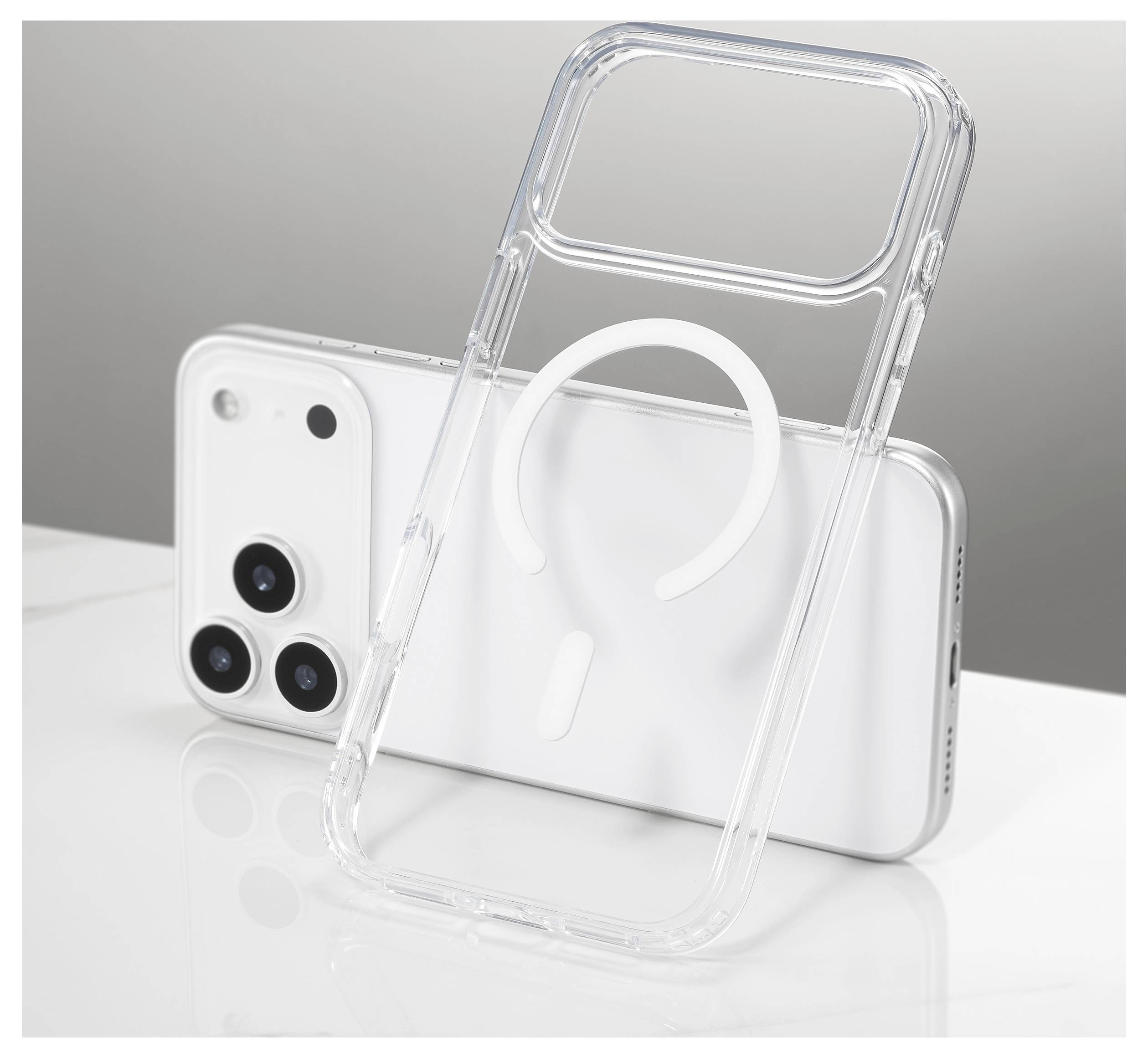 Eine durchsichtige Smartphone-Hülle mit einem weißen kreisförmigen Muster lehnt an einem weißen Smartphone mit dreifacher Kameralinse auf einer reflektierenden Oberfläche.