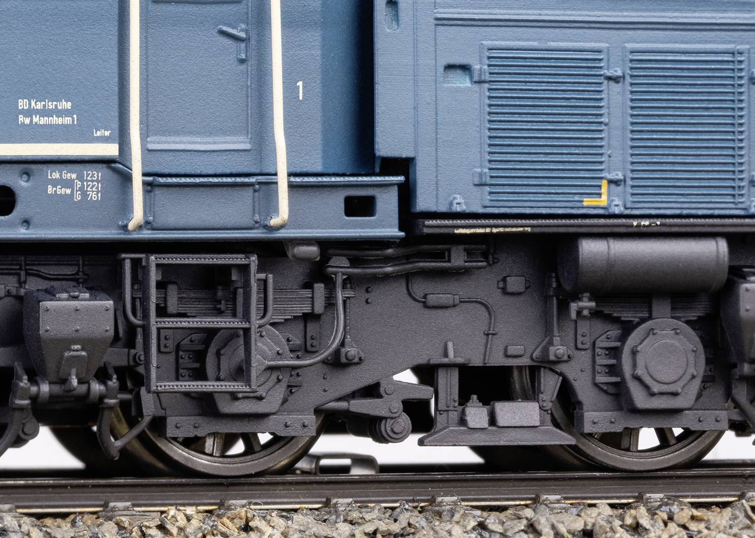Nahaufnahme eines blauen Zugwaggon-Radsatzes auf Schienen. Detaillierte Darstellung der Mechanik und Texturen der Zugfahrwerke.