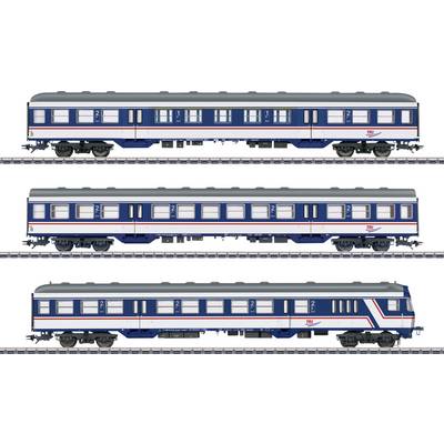 Drei Modelleisenbahn-Personenwagen auf Gleisen, in blauer und weißer Lackierung mit roten Streifen, von der Seite gezeigt.