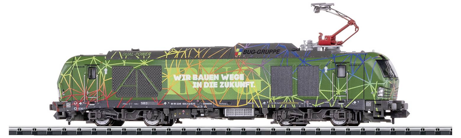 Grüne Lokomotive mit buntem geometrischen Muster und dem Schriftzug 'Wir bauen Wege in die Zukunft'. Oben Stromabnehmer.