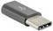 USB-C-Adapter, schwarz, mit USB-Logo, kompakt und metallisch, dient zur Verbindung von Geräten mit unterschiedlichen Anschlüssen.