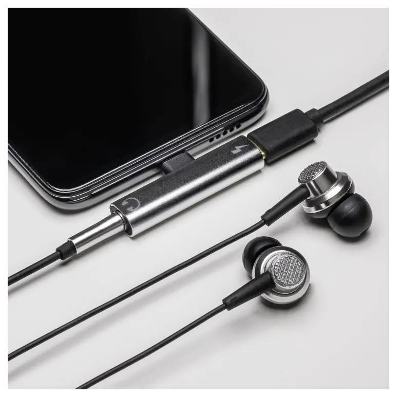 Schwarzes Smartphone verbunden mit silbernen kabelgebundenen In-Ear-Kopfhörern auf weißem Hintergrund.