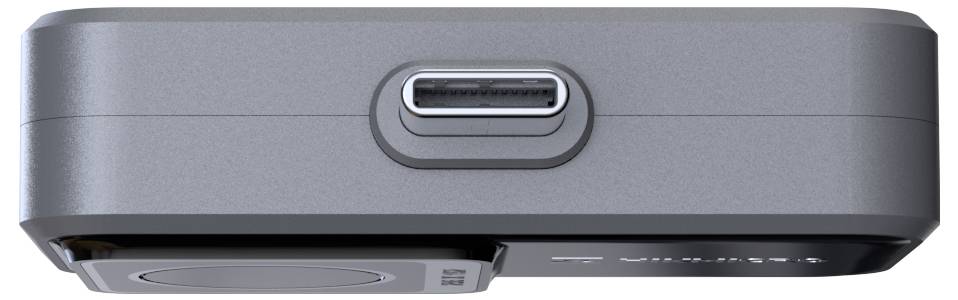 Die Abbildung zeigt den USB-C-Anschluss eines grauen elektronischen Geräts in der Nahaufnahme, auf einer weißen Oberfläche liegend.