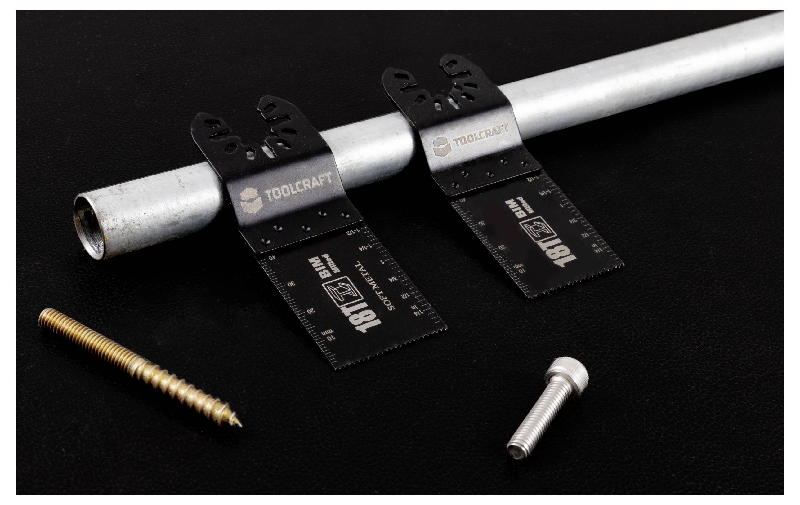 Metallrohr und zwei schwarze Messwerkzeuge mit der Aufschrift "TOOLCRAFT" liegen auf einer dunklen Oberfläche, zusammen mit einer goldenen Schraube und einem silbernen Bolzen.