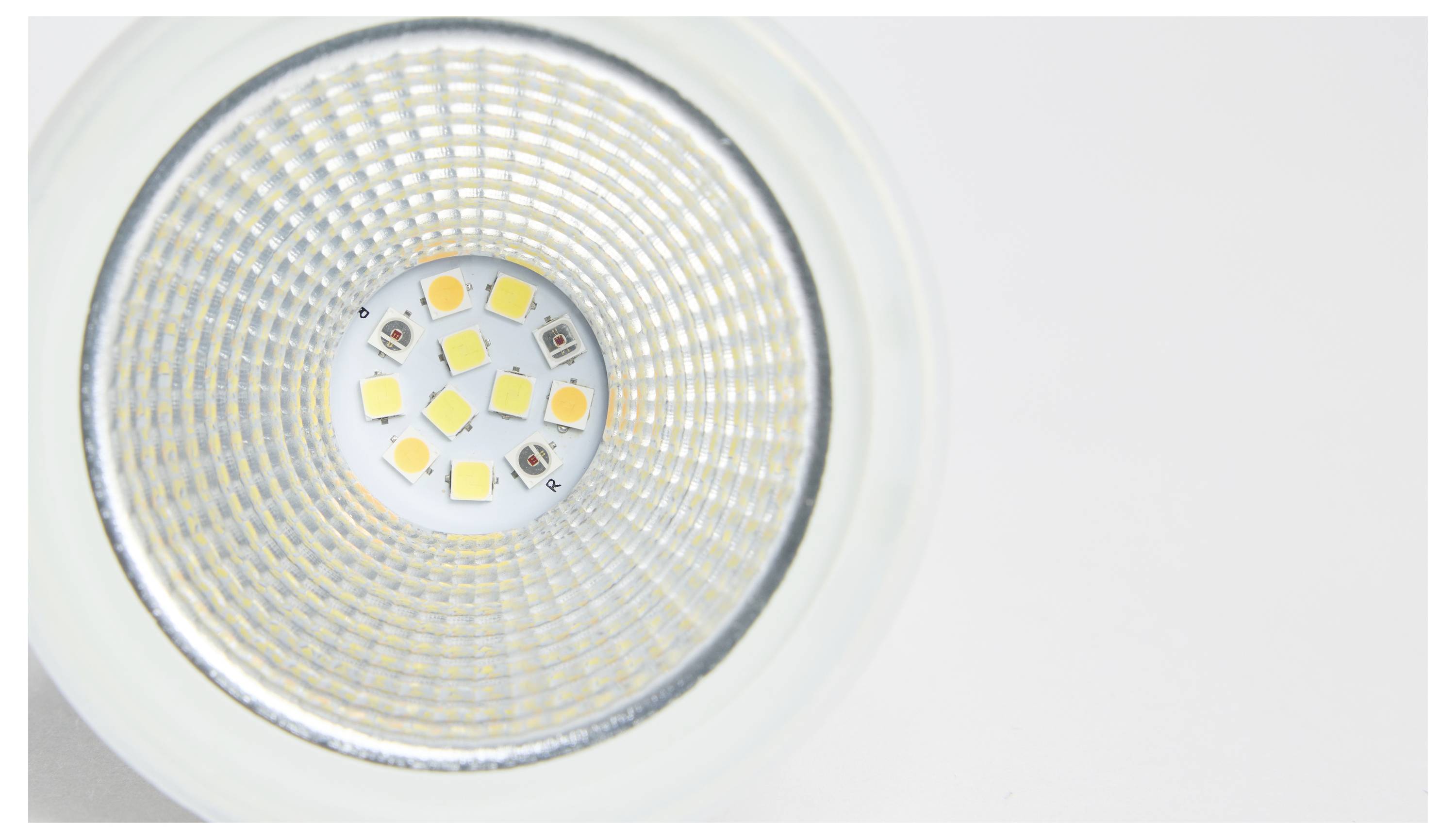 Nahansicht einer LED-Lampe mit sichtbaren LED-Chips in einem kreisförmigen Gittermuster, vor einem weißen Hintergrund.
