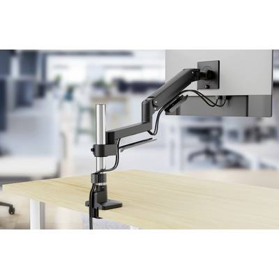 Ein Monitor mit verstellbarem Arm ist auf einem Büroschreibtisch montiert. Der Hintergrund zeigt eine unscharf gehaltene Büroumgebung als Kontextgeber.
