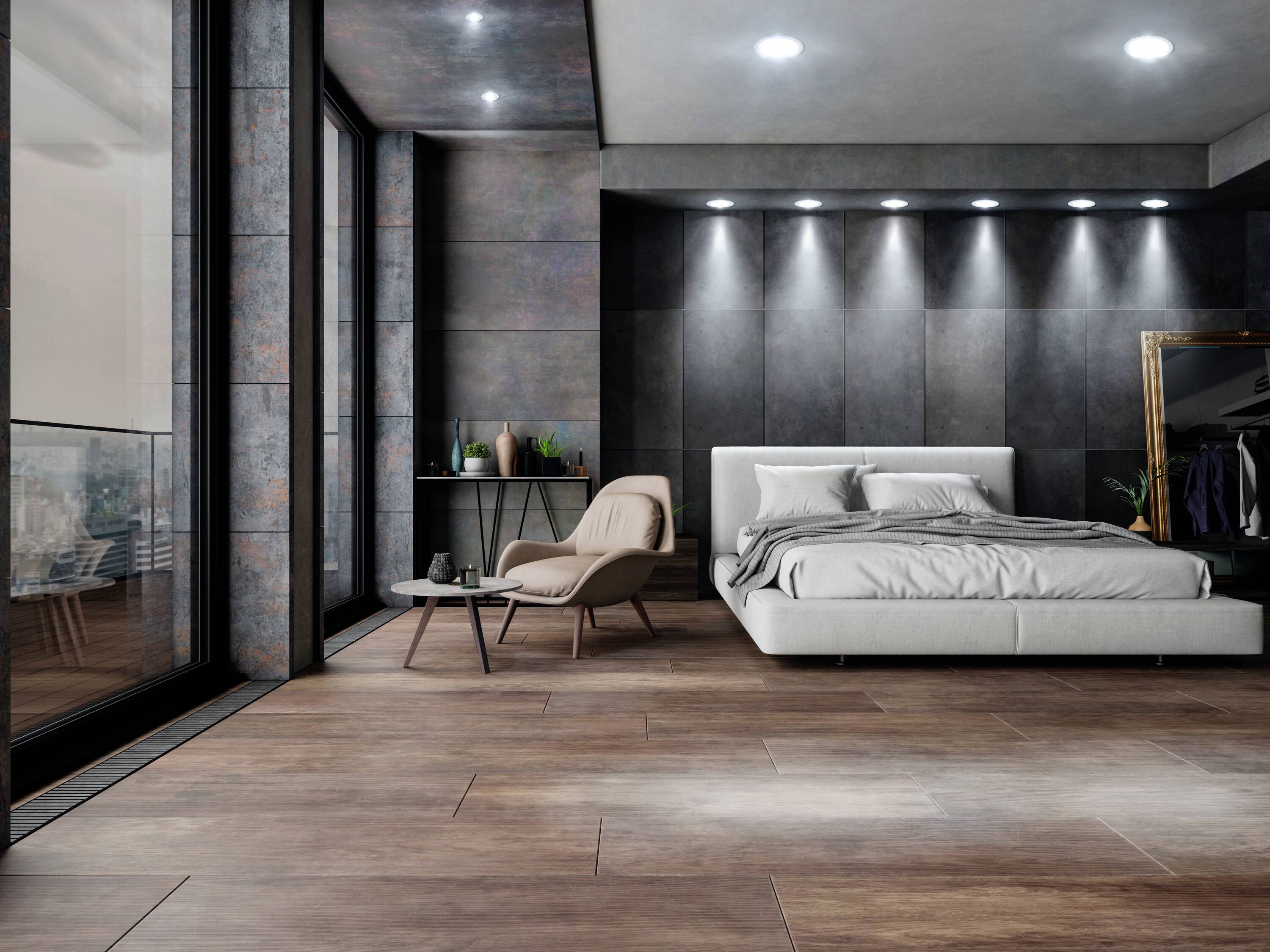 Ein modernes Schlafzimmer mit großen Fenstern, einem Bett, einem Sessel und einem Tisch. Dunkle Wände und Holzfußboden schaffen eine luxuriöse Atmosphäre.