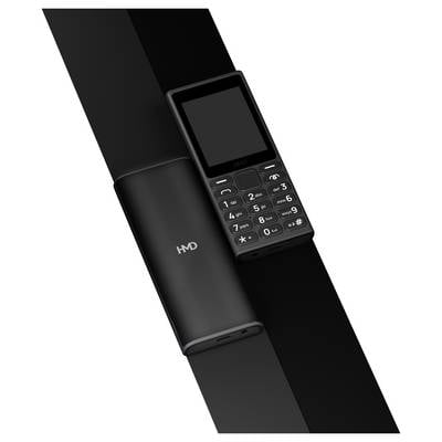 Ein schlichtes Handy mit Tasten, neben einem zylinderförmigen Ladegerät, beide in Schwarz und mit ähnlichem Design.