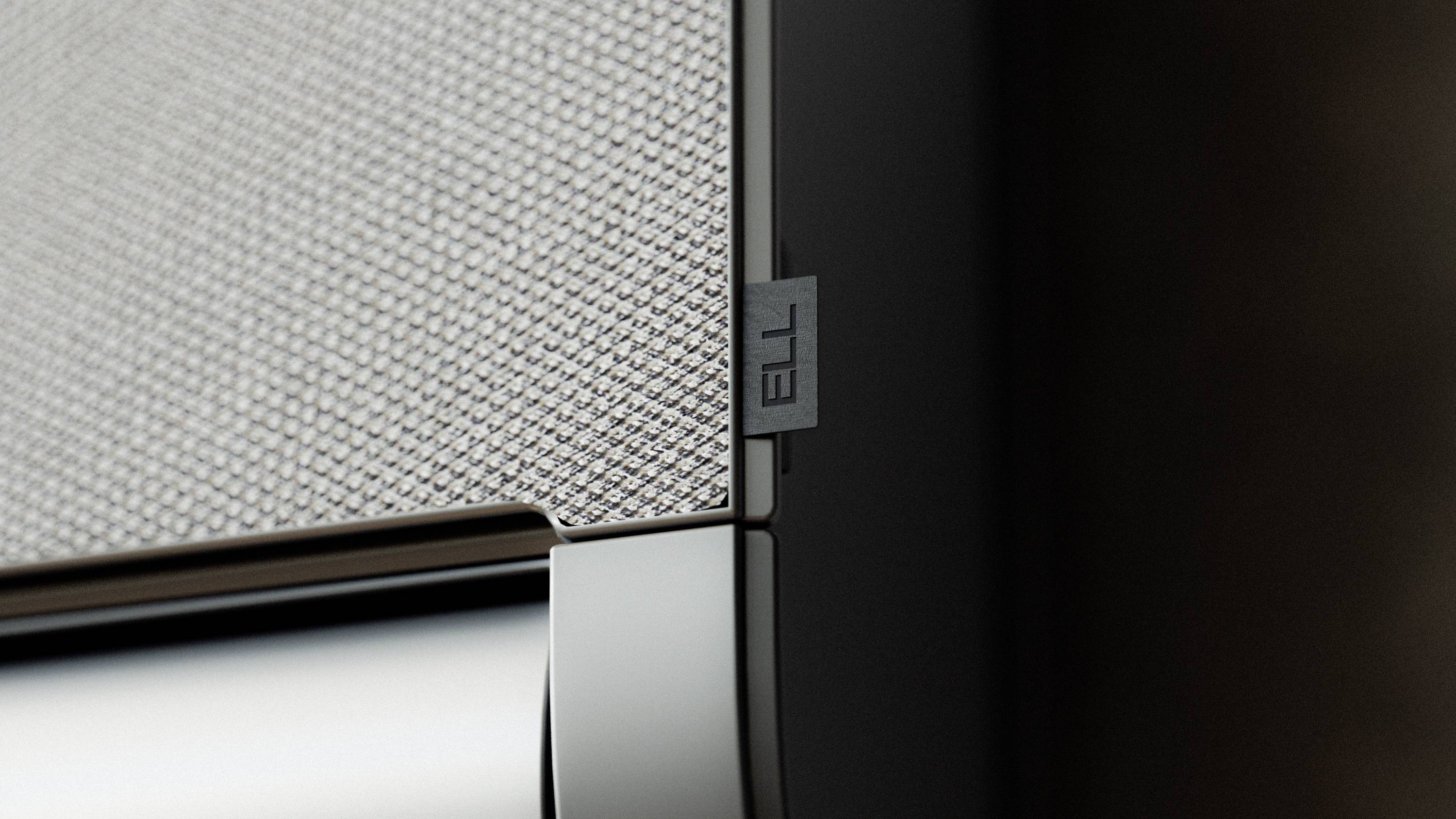 Ecke eines modernen Lautsprechers mit Stoffbespannung und Metallakzent. Fokus auf minimalistisches Design und hochwertige Materialien.