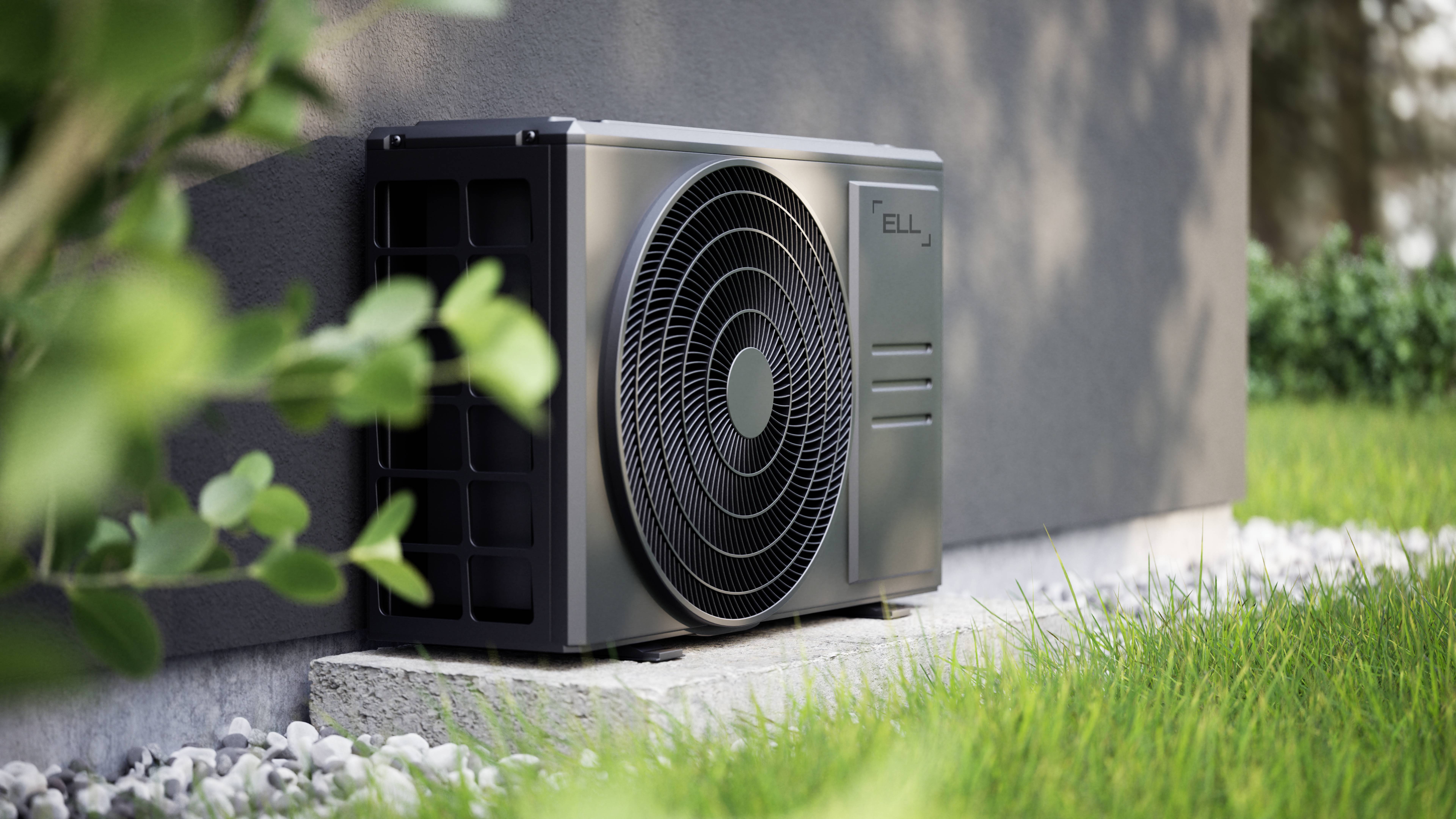 Metallische Wärmepumpeneinheit an der Außenseite eines Gebäudes, umgeben von Gras und Pflanzen, symbolisiert Energieeffizienz.