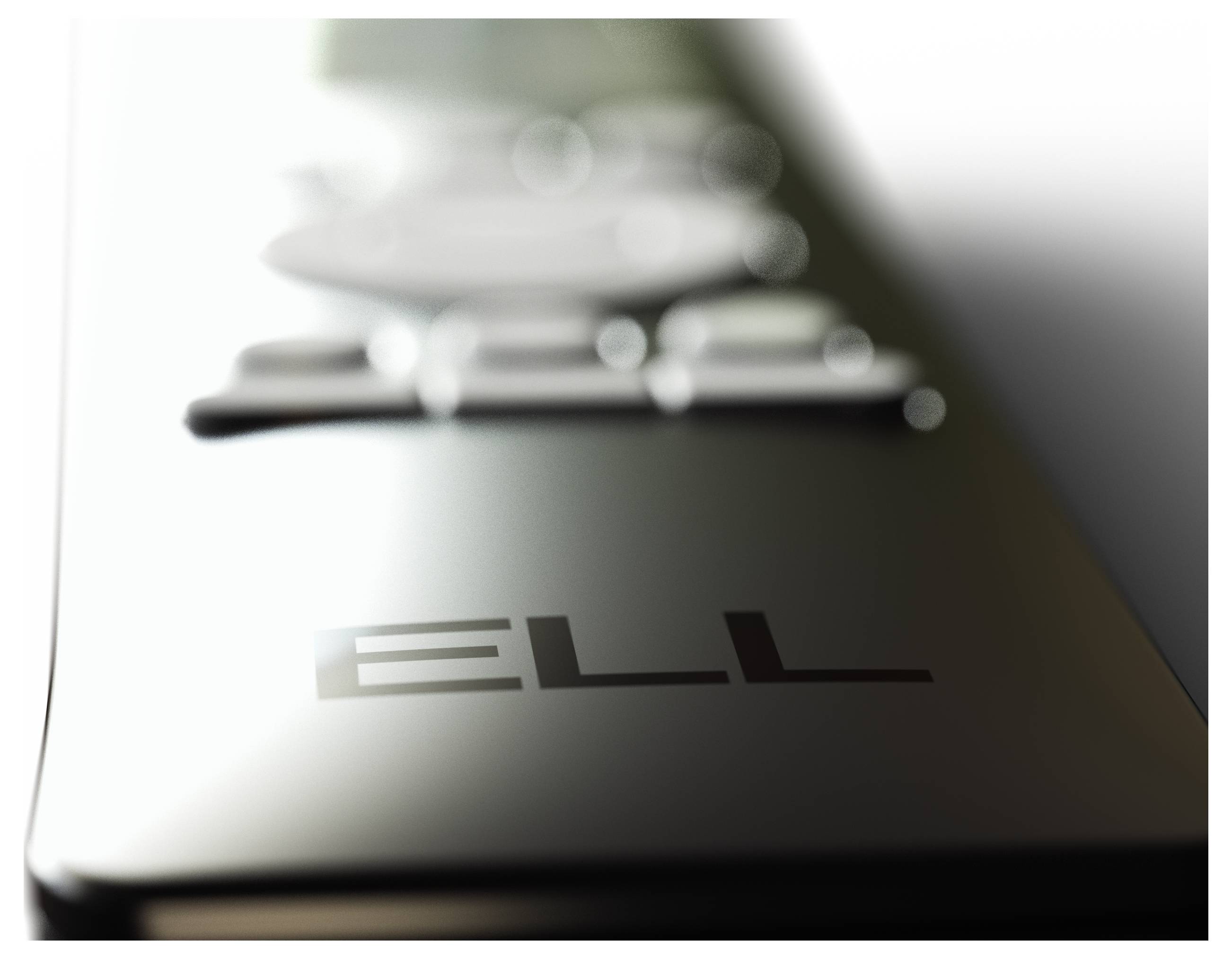 Metallische Oberflächenstruktur mit dem Wort 'ELL' eingraviert. Reflektiert Licht und zeigt Unschärfe im Hintergrund.