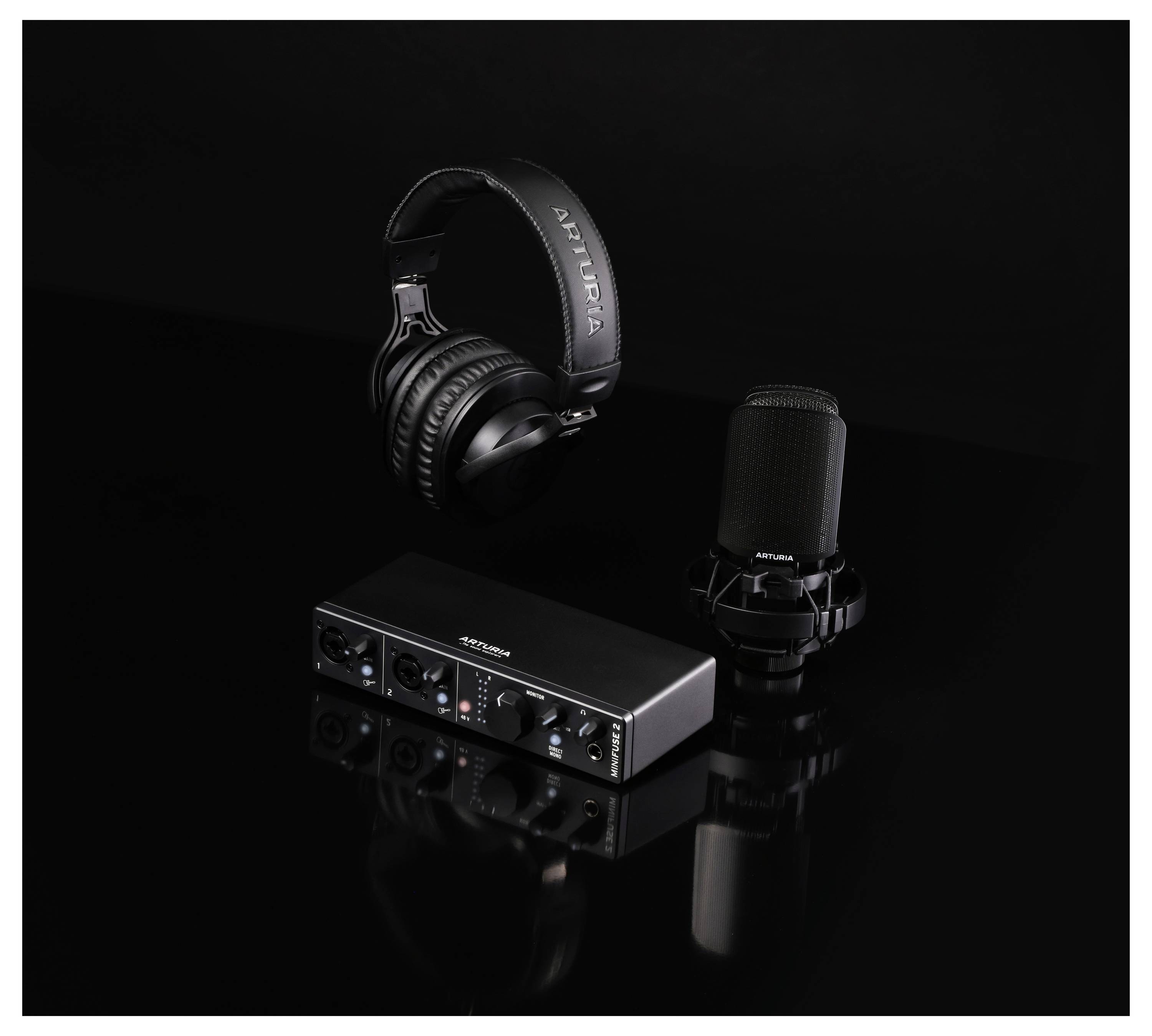 Ein Studio-Aufnahmeset bestehend aus einem Mikrofon mit Ständer, Kopfhörern und einem Audiomischpult, alles in Schwarz auf einem dunklen Hintergrund.