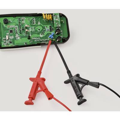 Eine grüne Leiterplatte mit elektronischen Komponenten ist mit einer roten und schwarzen Messsonde verbunden. Der Zweck des Geräts umfasst elektrische Messungen.
