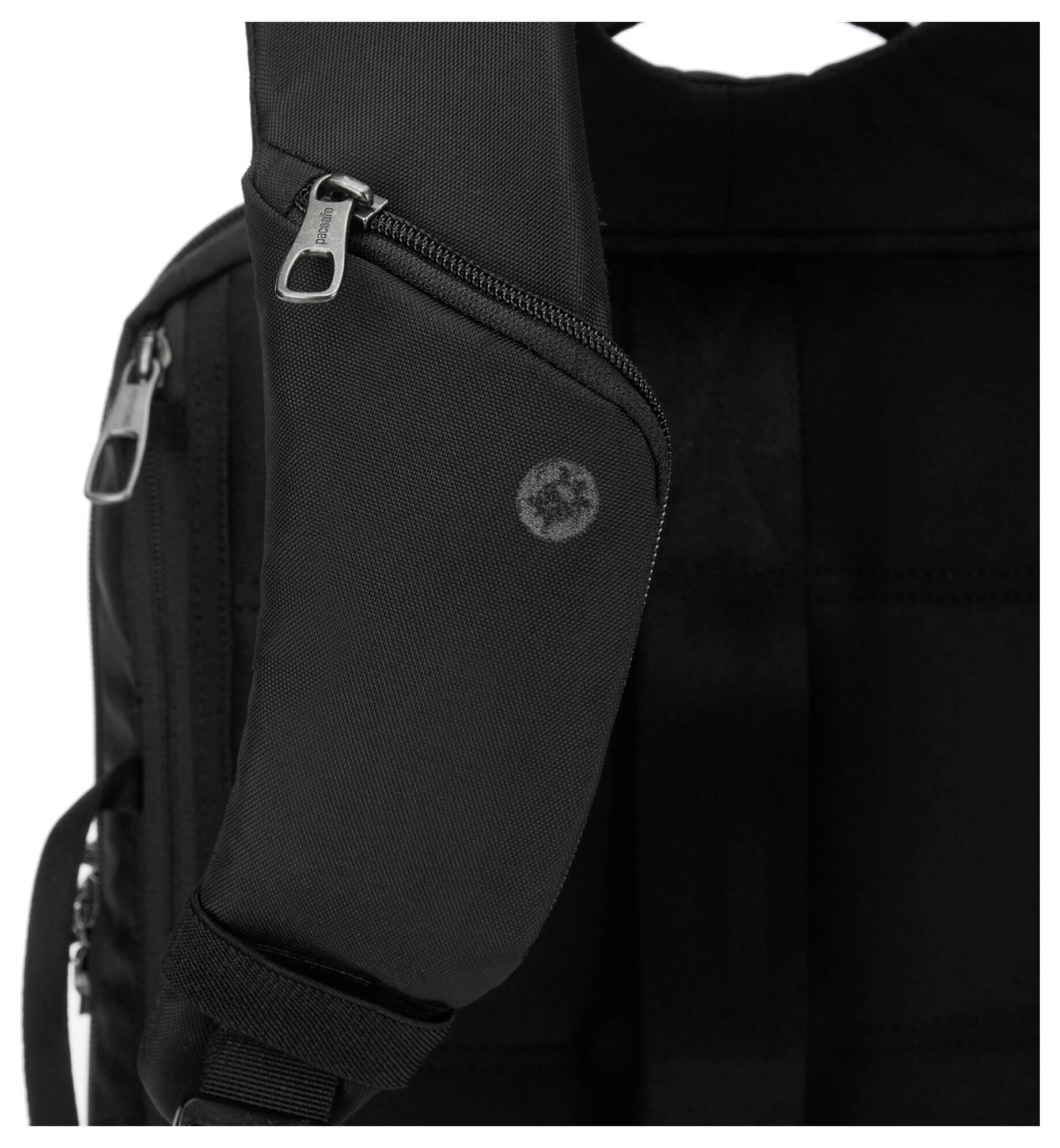 Nahaufnahme eines schwarzen Rucksackgurts mit einem Reißverschluss und einem kleinen kreisförmigen Logo. Der Gurt verfügt über einen gepolsterten Bereich für zusätzlichen Komfort.