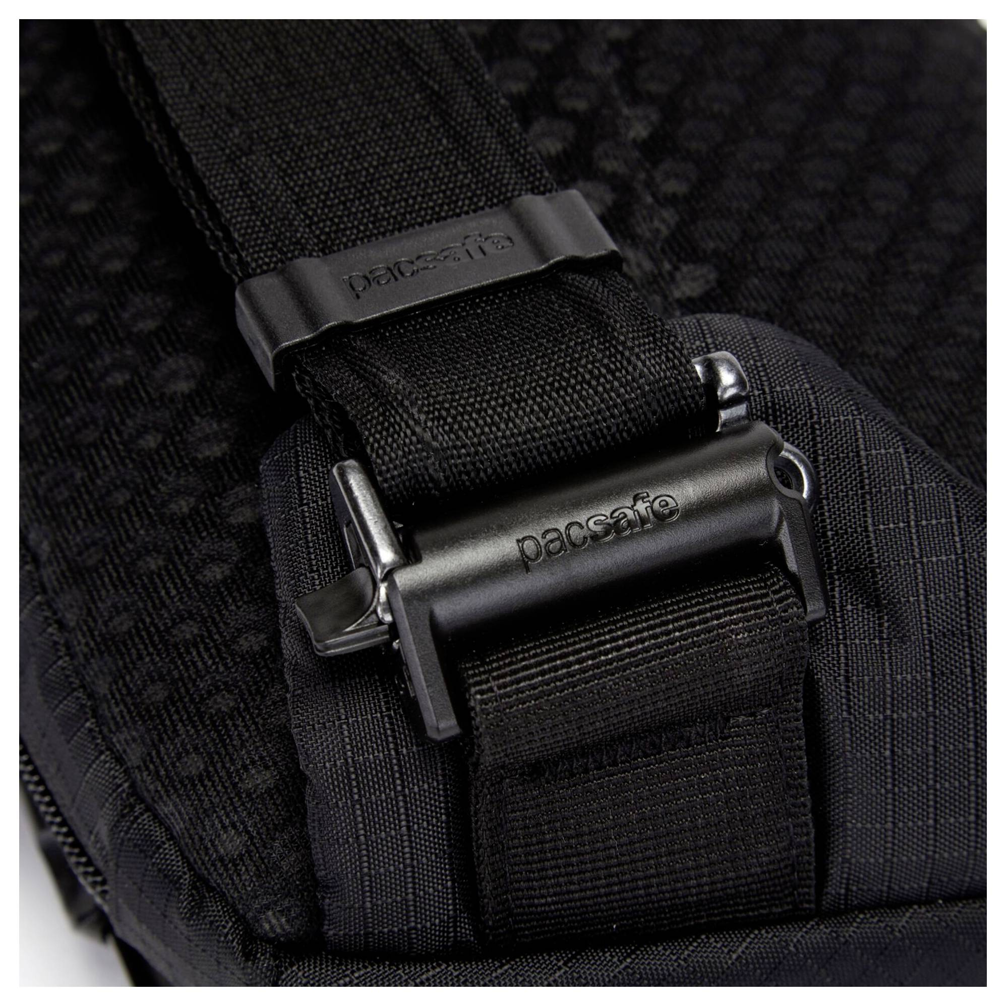 Eine Nahaufnahme eines schwarzen Rucksackgurts mit einer sicheren Schnalle, auf der die Marke 'pacsafe' in das Metallverschluss eingraviert ist.