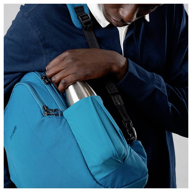 'Person schiebt eine Metallflasche in die Tasche eines blauen Rucksacks.'