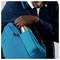 'Person schiebt eine Metallflasche in die Tasche eines blauen Rucksacks.'