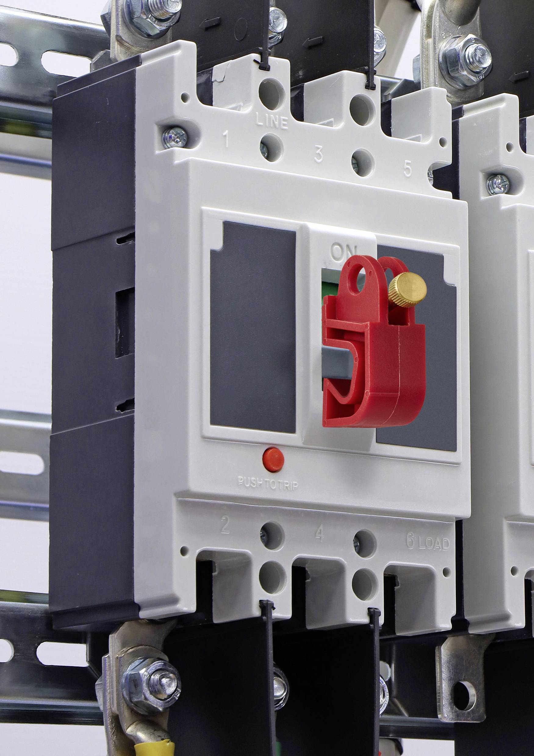 Eine Nahaufnahme eines industriellen Leistungsschalters mit einem roten Schalter in der 'EIN'-Position, montiert auf einem Metallrahmen, wobei ein Teil seiner Verkabelung sichtbar ist.