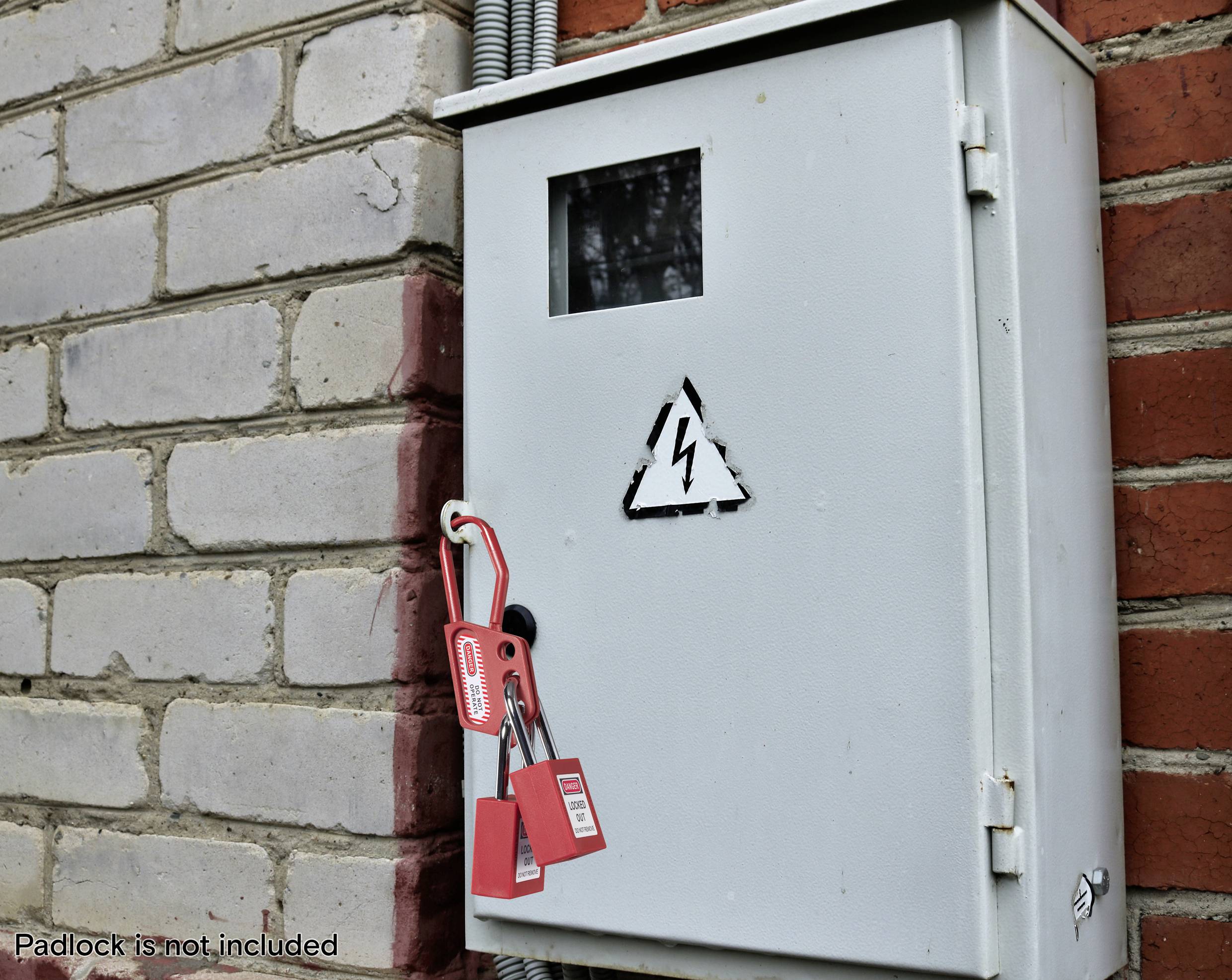 Elektrische Verteilerdose an einer Ziegelwand mit einem Hochspannungs-Warnschild. Ein roter Vorhängeschloss mit Anhängern hängt an der Verriegelung.