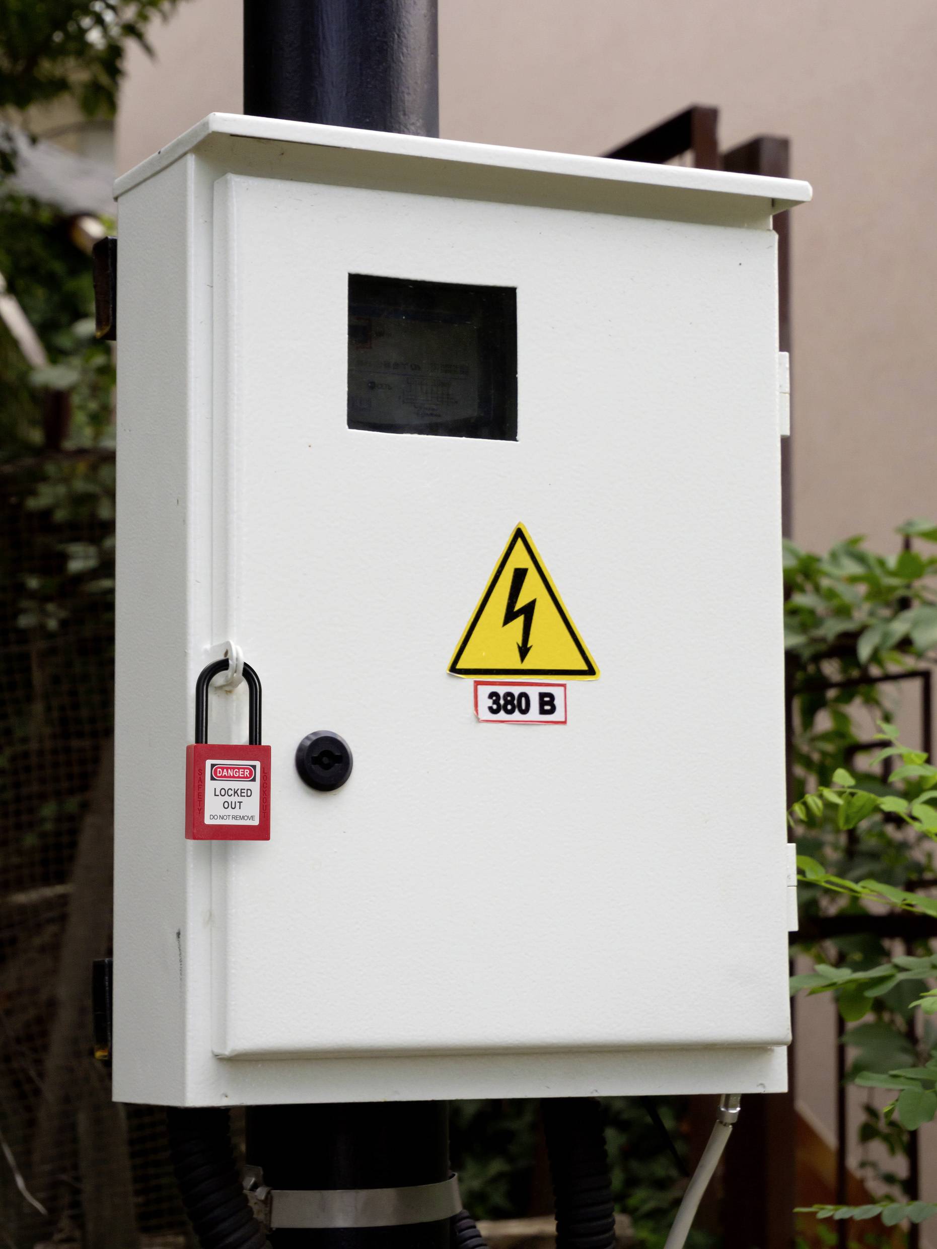 Ein elektrisches Panel mit einem Sperrhinweisschild und der Spannungsbezeichnung "380 V", was auf eine hohe Spannung hinweist. Das Panel ist gesichert und im Freien montiert.